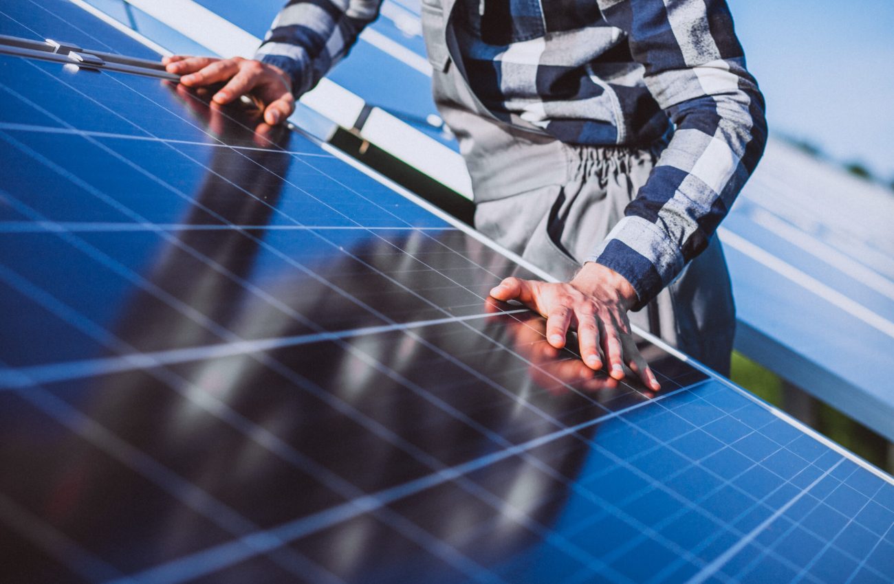 Man worker in the firld by the solar panels Man worker in the firld by the solar panels